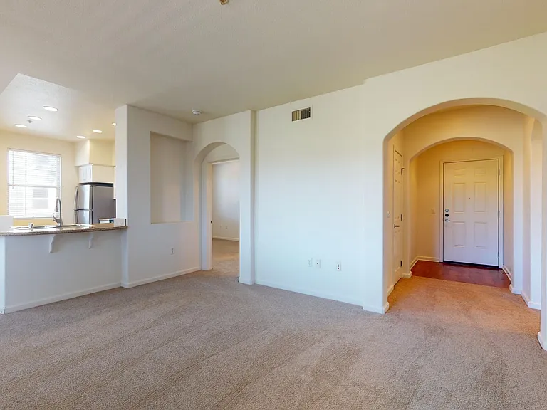 Apartment living room with plush carpet flooring.