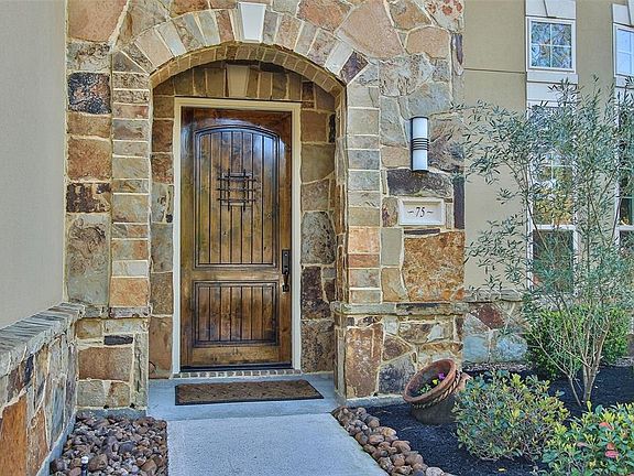 What's more inviting than a single solid wood front door surrounded by Austin stone and modern outdoor light.