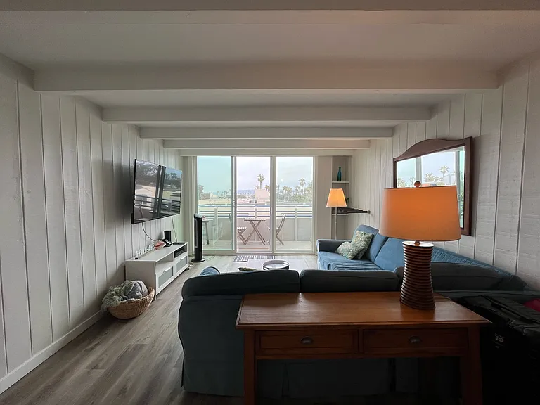 Ample large sofa, and patio balcony with views of ocean, bay, Sea World fireworks, and Mt Soledad in La Jolla.