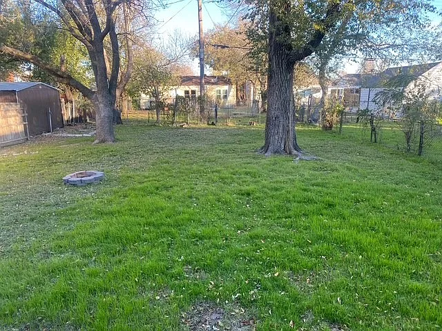 large fenced backyard with mature trees