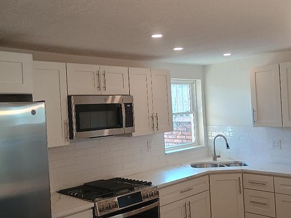 Kitchen area with stainless steel appliances and granite countertops/island