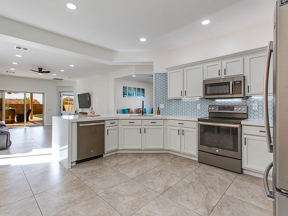 Tiled Backsplash, Waterfall Counter Top, Electric Stove Top, Motion Under and over Cabinet Lighting