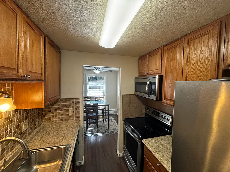 Galley kitchen with upgraded appliances and pantry .
