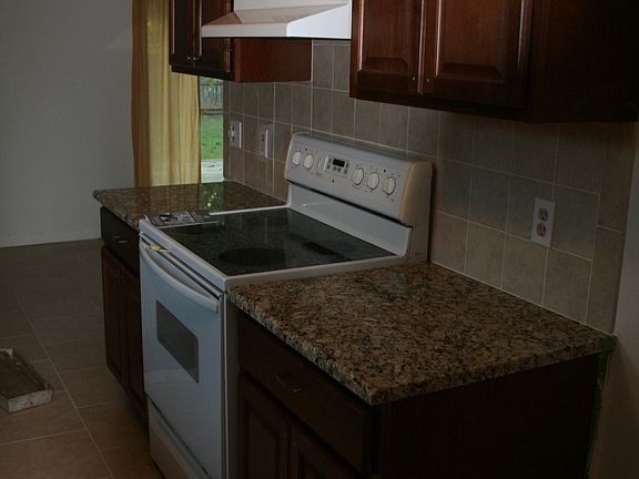 Kitchen with new cabinets, granite counter tops, vent hood and floor