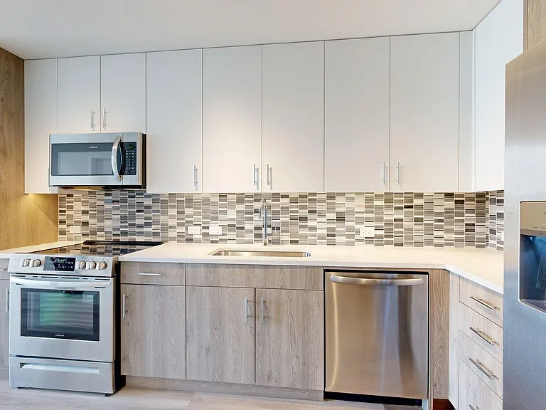 Apartment Kitchen with Quartz counter tops and Wood Style Flooring.