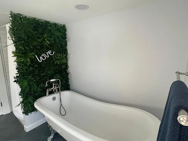 A clawfoot tub with a (faux) living wall- perfect to melt away the stress of the day.