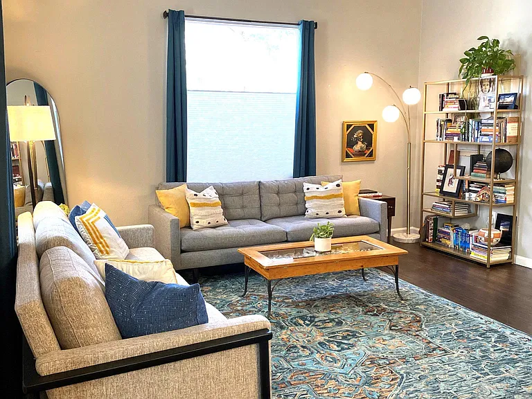 Spacious living room with large windows and upgraded ceiling fan