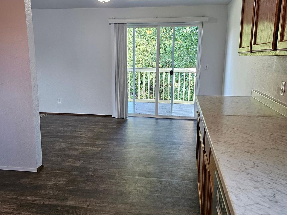 This photo shows the kitchen, dining area and slider door to the deck.