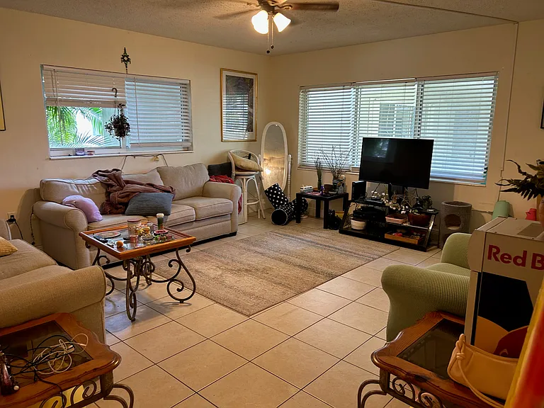 Living room furnished with sofa and matching loveseat and Smart TV, end tables