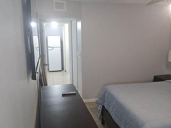 TV nightstand with refrigerator in the background