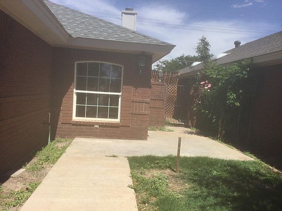 Front entrance and side yard . Front yard has rod iron fence enclosure.