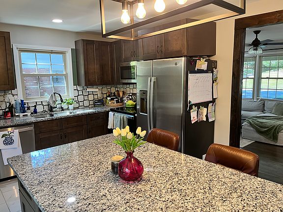 Updated kitchen with stainless steel appliances, backsplash and light fixtures.