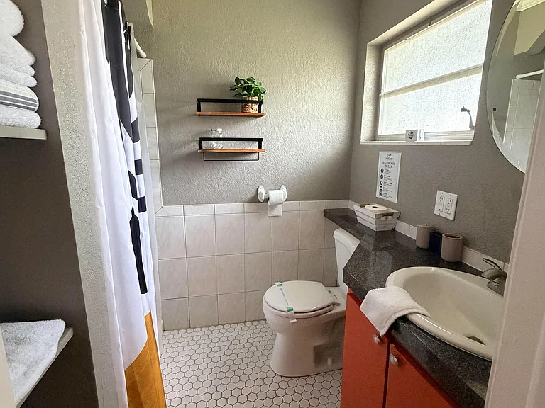 Well-appointed bathroom with a shower/tub combo, tiled finishes, and a single-sink vanity with storage and counter space.