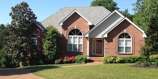 Front of all brick home. Notice the arched windows and interesting roof lines.