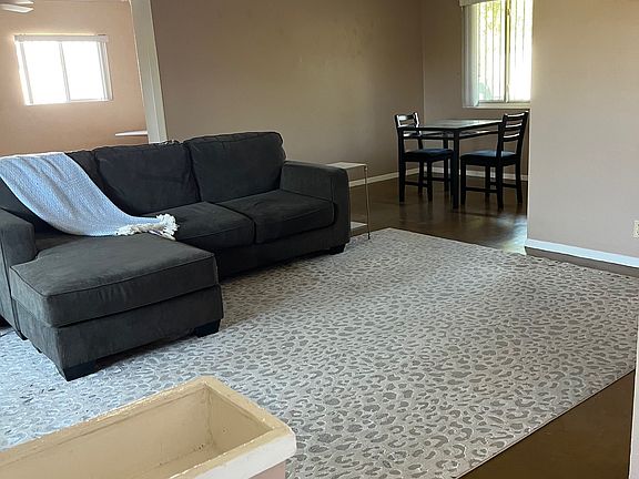 View from front entryway into large living room with alcove front window, dining area with large window in back looking out onto back porch and back yard. Behind couch is the entryway into the bonus room that also has a doorway into the back yard.