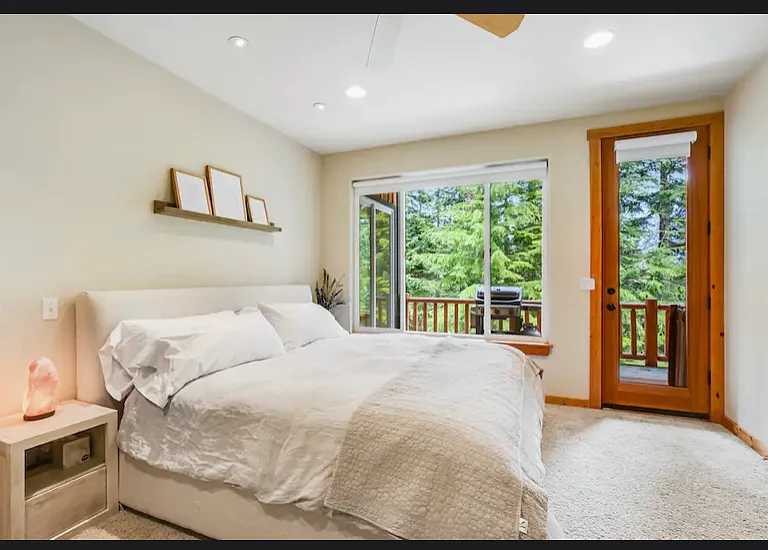 large primary bedroom with views of the patio and door out to the hot tub