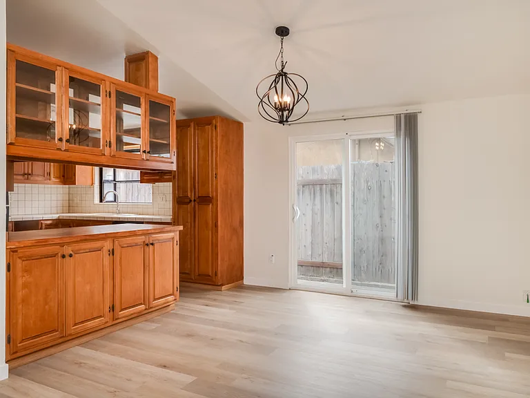 Dining room with new light fixture and sliding glass door.