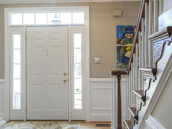 Sunlit foyer with transom window & hardwood floor