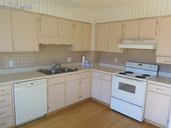 Large eatin country kitchen has a oak wood floor