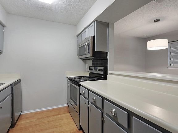 Designer's Grey kitchen with Stainless Steel Appliances and Hardwood floors
