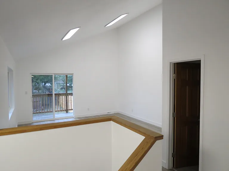 view from kitchen to living area/door to 1/2 bath