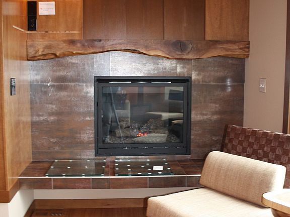 Sliding doors hide flat panel TV location above gas fireplace.