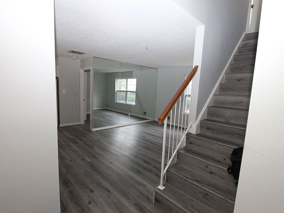 As you enter, family room with recently upgraded flooring and wall-sized mirror