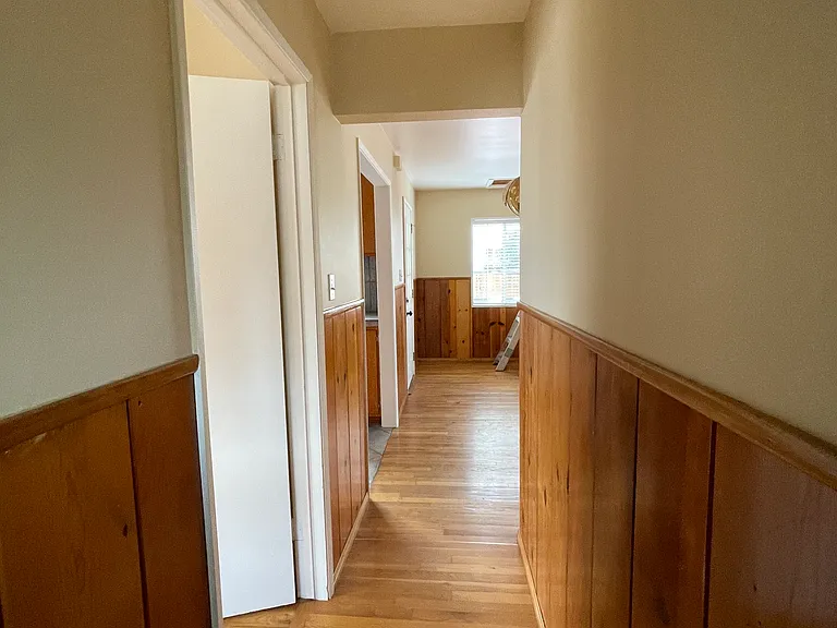 hallway leading from the bathroom to bedroom(L) and to dining area.