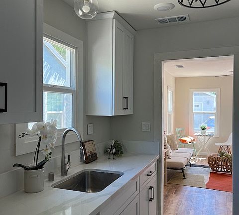 Beautiful and bright kitchen. Stainless steel appliances including gas stove, dishwasher, refrigerator, microwave hood. White shaker cabinetry and white quartz counter top and backsplash, white tile flooring, LED lighting.