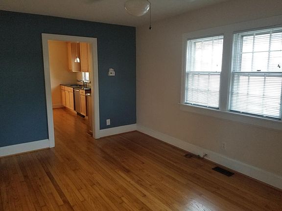 Living room with hardwood floors, big windows, and a ceiling