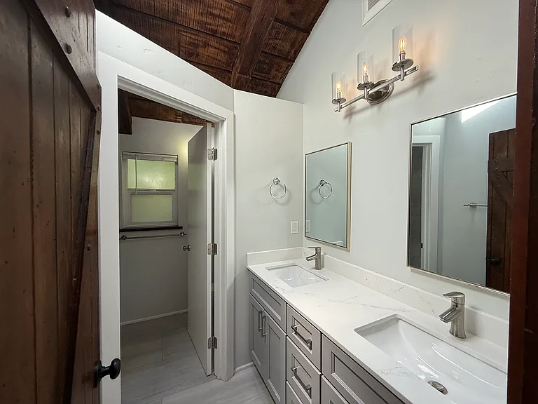 Hallway Bathroom #1 has 2 sinks and a bathtub.