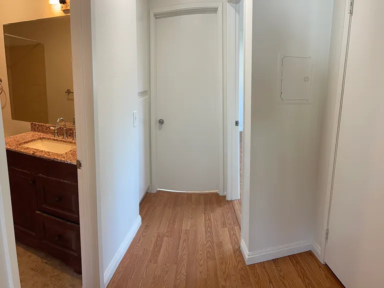 hallway for 2 bedrooms and bathroom, storage closet to the right, storage cupboards to the left