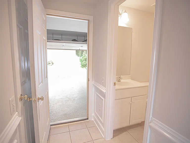 Half bath on the right, garage straight ahead, additional coat room / storage under the stairs