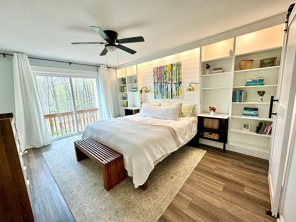 Large master bedroom with king bed, two closets, built in book shelves and sliding door to the back porch