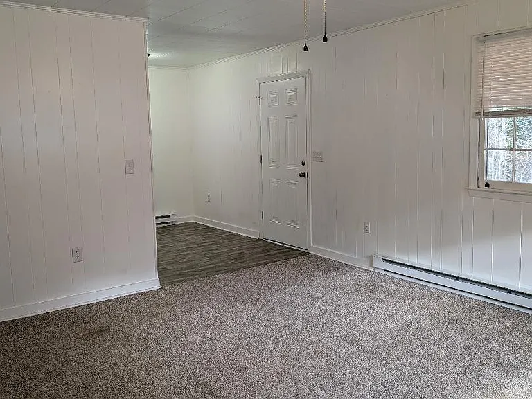 FRONT ENTRANCE INTO LARGE LIVING ROOM. STORAGE CLOSET TO THE LEFT WITH LIGHTED CEILING FAN