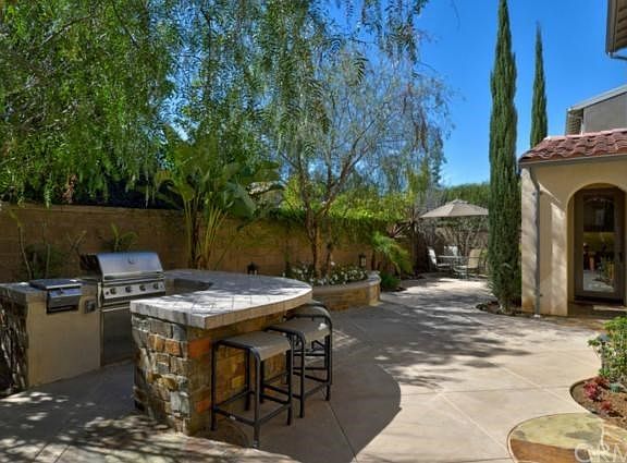 Gorgeous Backyard with Custom Stone Barbecue Island, Planters, Specimen Trees and Private Seating Ar