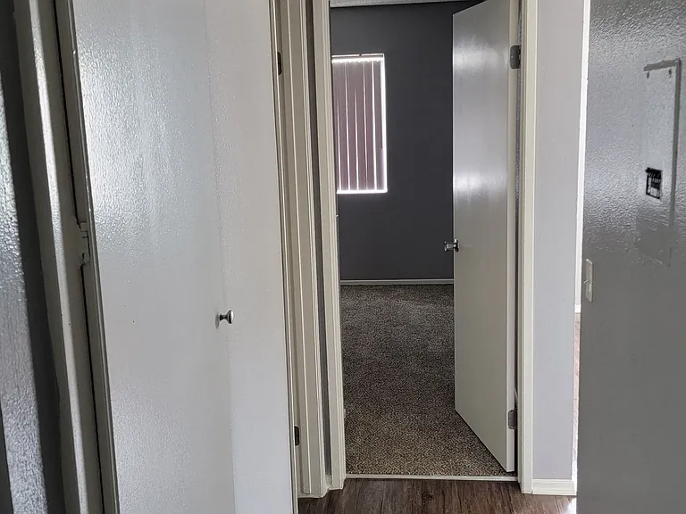 Bedroom with vertical blinds on large widow at Grand Oaks Apartments in Lake Elsinore, California.