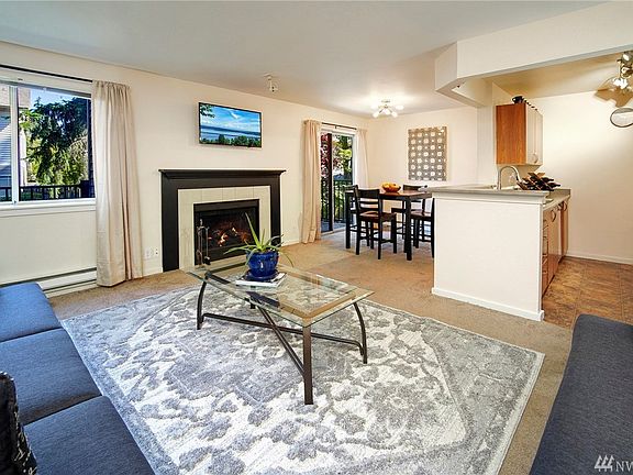The living room features a handsome wood burning fireplace and lots of natural light. Right off the dining room is the sliding glass door to your private deck. 