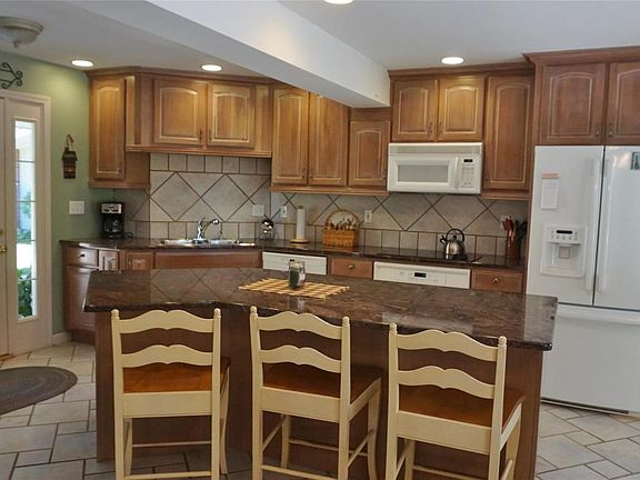 Lovely kitchen has custom, crowned cabinets & granite counters.