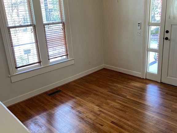 Spacious living room/office space features original flooring, fireplace (non working), double paned windows, ceiling fan and door with side lights