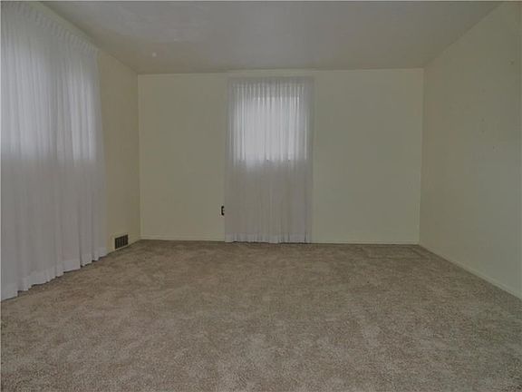 A view of the Living Room from the center stair.  Note there is ALL brand new, neutral colored wall to wall carpeting on the mai