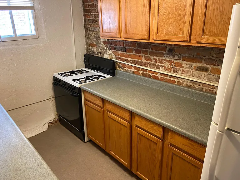 Kitchen looking right to left photo #2. Full size gas stove large counter space with oak cabinets