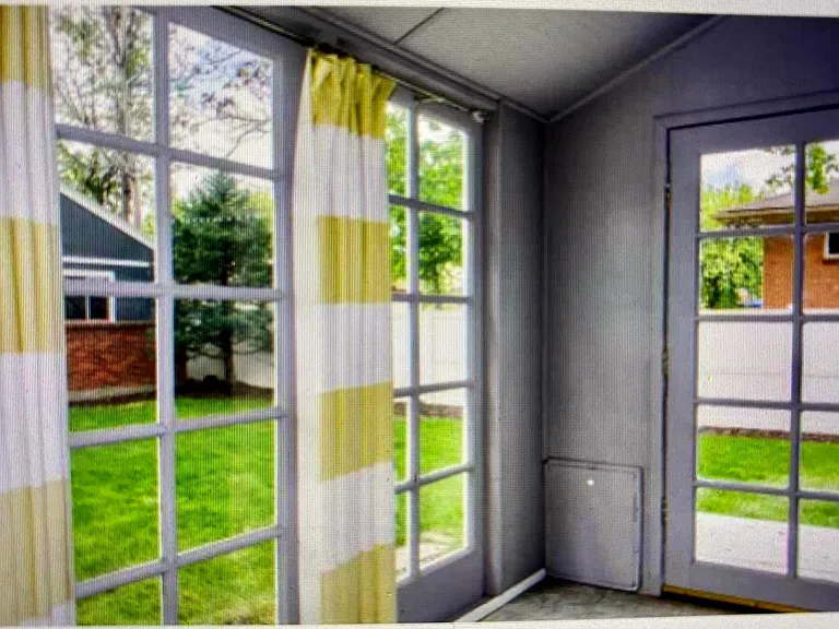 Sunroom with view of backyard. Dog door.