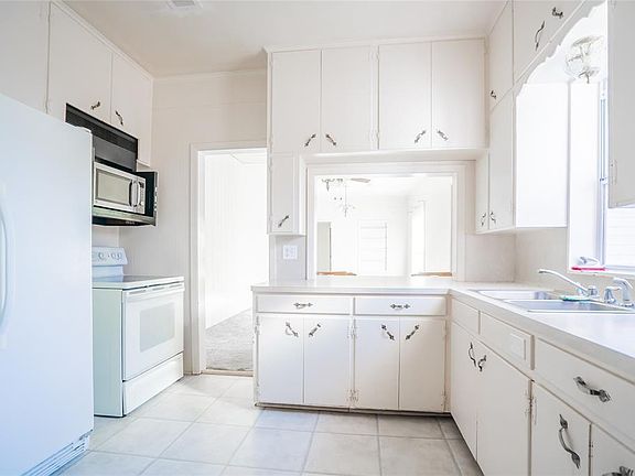 Kitchen with microwave, stove, and side by side refrigerator. Lots of cabinet space.