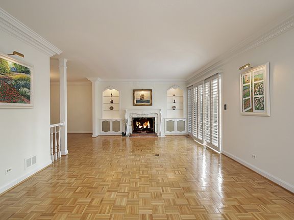 Living room with detailed crown molding, custom built-ins & gorgeous marble fireplace.