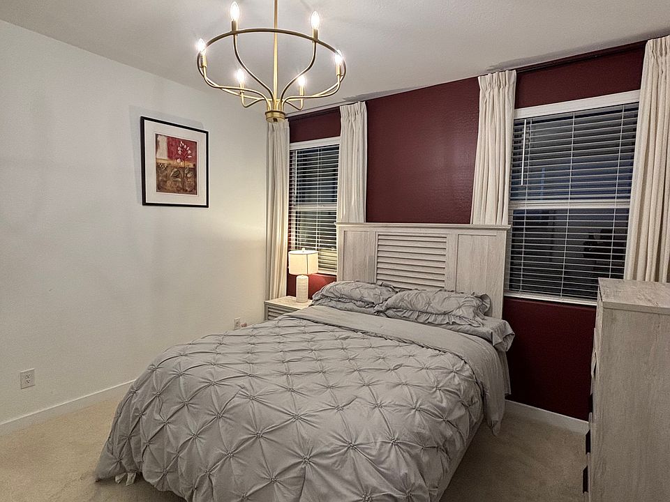 Primary bedroom featuring queen bed set with night stand plus lamp, dresser with mirror and wardrobe, walk in closet, and chandelier