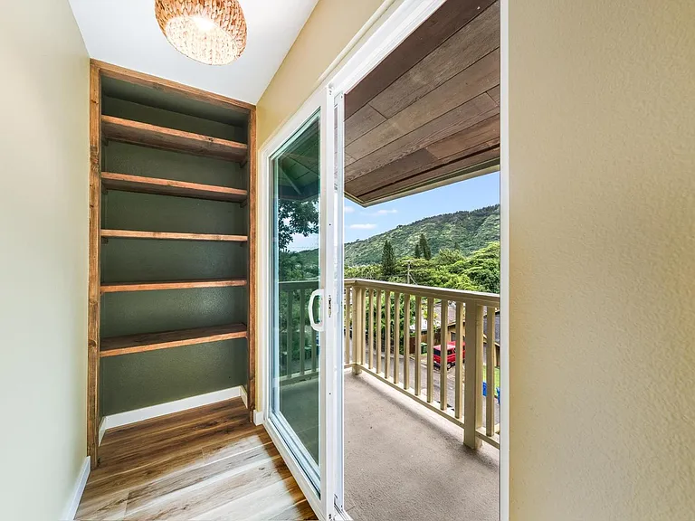 Master bedroom retreat with built-in shelving and direct access to a private balcony.