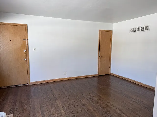 Living room view from kitchen/dining. Main door to left, closet to right.