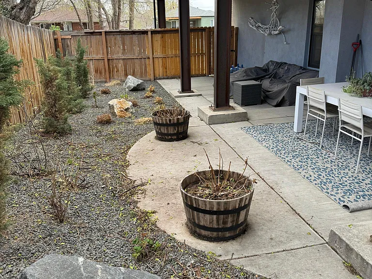custom landscape next to dining area, with covered area for weather proof sitting