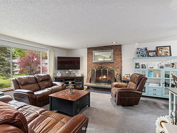 This living room welcomes you right in with a classic brick fireplace. Flows from kitchen and dining room!